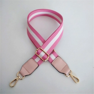 Close-up of pink and white striped canvas strap with gold swivel hooks and leather details