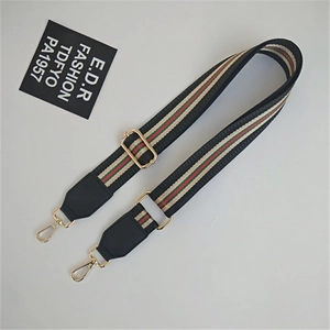 Detail of colorful woven shoulder strap with gold metal buckle and leather ends
