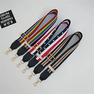 Detail of adjustable woven wide shoulder straps with golden metal snap hooks and leather ends