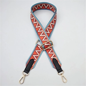 Detail of adjustable bohemian weave strap with orange geometric patterns and gold clips