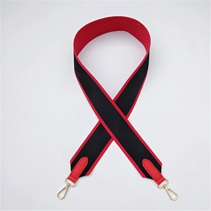 Detail of red and black wide fabric bag strap with golden metal swivel hooks