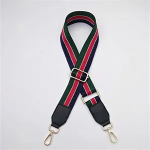 Détail d'une bandoulière de sac réglable avec rayures ethniques rouge-vert et crochets