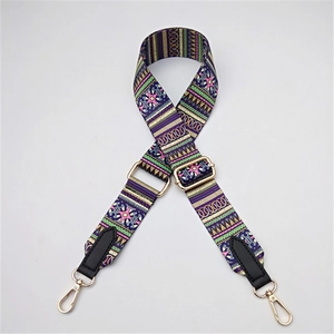 Macro shot of ethnic bohemian style adjustable purple woven bag strap with golden buckles