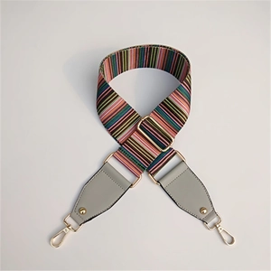 Close-up of colorful striped wide handbag strap with gold metal hooks and gray leather