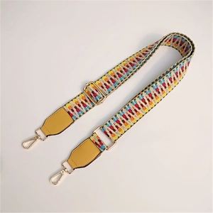 Close-up of colorful woven shoulder strap with gold metal hooks and yellow leather details