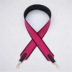 Detail of rose red and black canvas strap with gold metal hooks and leather reinforced ends