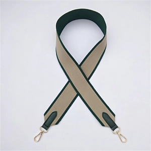 Close-up of wide dual-color woven strap with dark green leather and gold metal buckle
