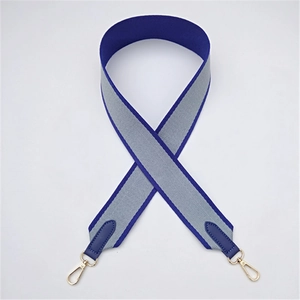 Detail of wide nylon bag strap with blue and grey color block and gold lobster clasp