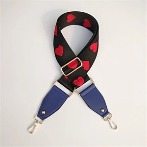 Close-up of black fabric strap with red heart embroidery and blue faux leather ends