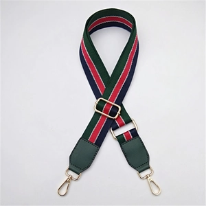 Détail de la bandoulière réglable à rayures vertes et rouges avec mousquetons dorés