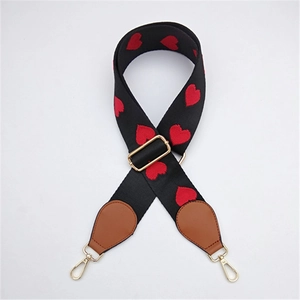 Detailed view of adjustable black wide strap with red heart embroidery and gold metal hooks
