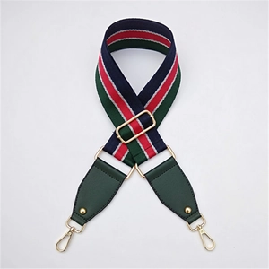 Détail d'une bandoulière tissée réglable avec rayures marine, rouge, vert et métal doré