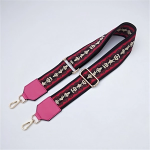 Close-up of ethnic geometric pattern strap with golden metal lobster clasps and pink leather