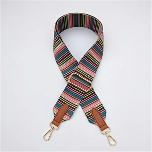 Détail de la sangle en tissu rayé avec boucles en métal doré et embouts en cuir brun