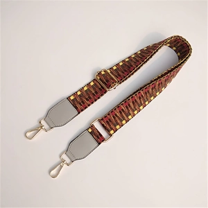 Detail of colorful woven ethnic purse strap with golden metal swivel hooks and leather ends