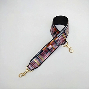 Macro detail of geometric patterned wide woven strap with gold metal lobster clasps