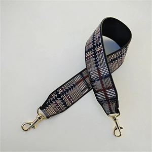 Close-up of wide geometric jacquard strap with gold metal swivel lobster clasps