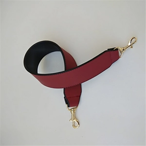 Close-up of wide PU leather handbag strap in wine red with gold metal lobster clasps