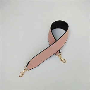 Detail of pink PU leather wide strap with golden lobster clasps and black backing