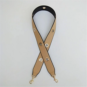 Close-up of wide PU shoulder strap with gold eyelets and swivel lobster clasps