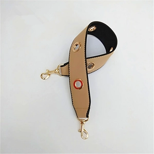 Macro shot of khaki and black wide PU shoulder strap with gold metal eyelet details