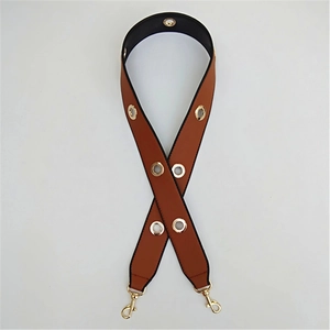 Close-up of brown PU leather strap with golden metal eyelets and lobster clasps