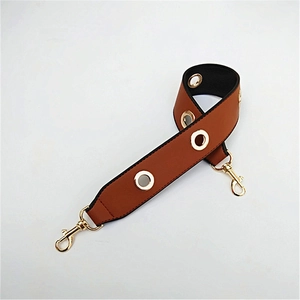 Close-up of brown PU leather shoulder strap with gold eyelets and metal lobster clasps