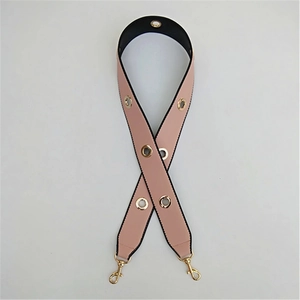 Detail of light pink and black PU leather replacement bag strap with gold metal eyelets