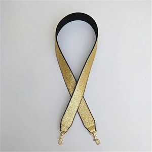 Detail of wide replacement bag strap with golden glitter finish and metal hooks