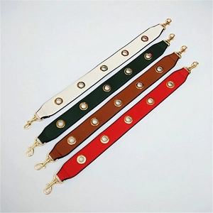 Macro view of wide PU leather purse straps with gold eyelets and metal lobster clasps