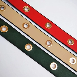 Detail of wide PU leather purse straps with gold eyelets in red, beige and green
