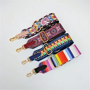 Detail of four thick adjustable crossbody bag straps with diverse patterns and gold hardware