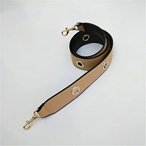 Detail of khaki PU leather wide strap with golden eyelets and lobster clasps