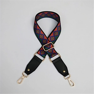 Detail of adjustable woven purse strap with colorful geometric patterns and gold metal hooks