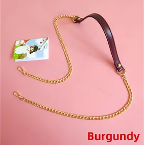 Close-up of maroon PU leather strap and gold metal chain with lobster clasps on pink background