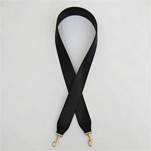 Dettaglio tracolla larga in pelle PU nera con cuciture rinforzate e fibbie metalliche oro