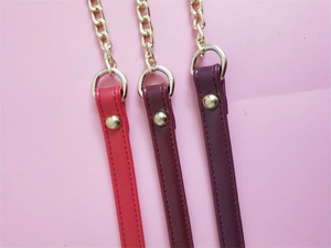 Detail view of red, maroon and purple PU leather bag straps with gold metal chain links