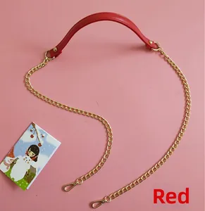 Detail of red PU leather bag handle with gold metal chains and lobster clasps