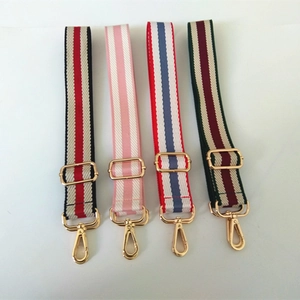 Close-up of four colorful striped adjustable polyester straps with gold metal hardware