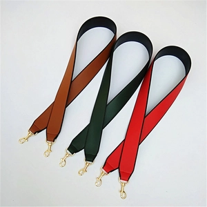 Dettaglio di tracolle larghe in pelle PU nei colori marrone caramello, verde e rosso