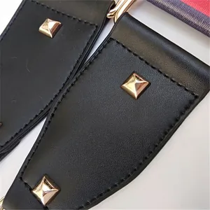 Detail of high-quality black leather strap with gold pyramid studs and neat stitching