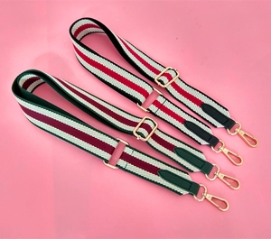 Detail showing adjustable canvas strap with green and red stripes and gold hardware