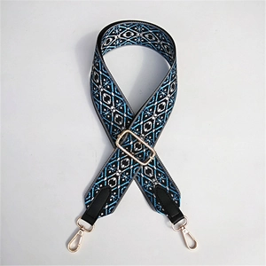 Detail of blue and black ethnic weave bag strap with golden buckles and leather ends
