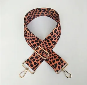 Detail of adjustable leopard print bag strap with golden metal swivel hooks and buckle