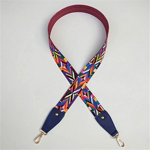 Dettaglio tracolla colorata in jacquard geometrico con terminali in pelle blu e ganci oro