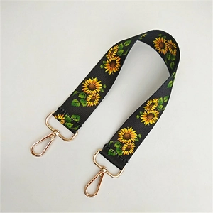 Detailansicht vom gewebten Taschengurt mit Sonnenblumenmuster und goldenen Metallhaken