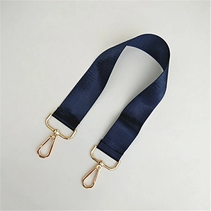 Nahaufnahme des dunkelblauen Nylon-Schultergurts mit goldenen Karabinerhaken für Taschen