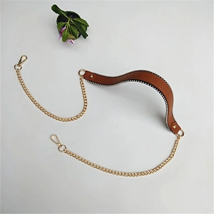Detail of brown leather strap with silver bead trim and gold chain attachment