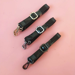 Three black patent leather replacement straps with gold, silver, and gunmetal buckles