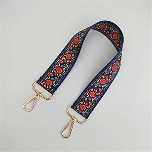 Detail eines Taschenriemens mit Ethno-Print und goldenen Metall-Karabinerhaken